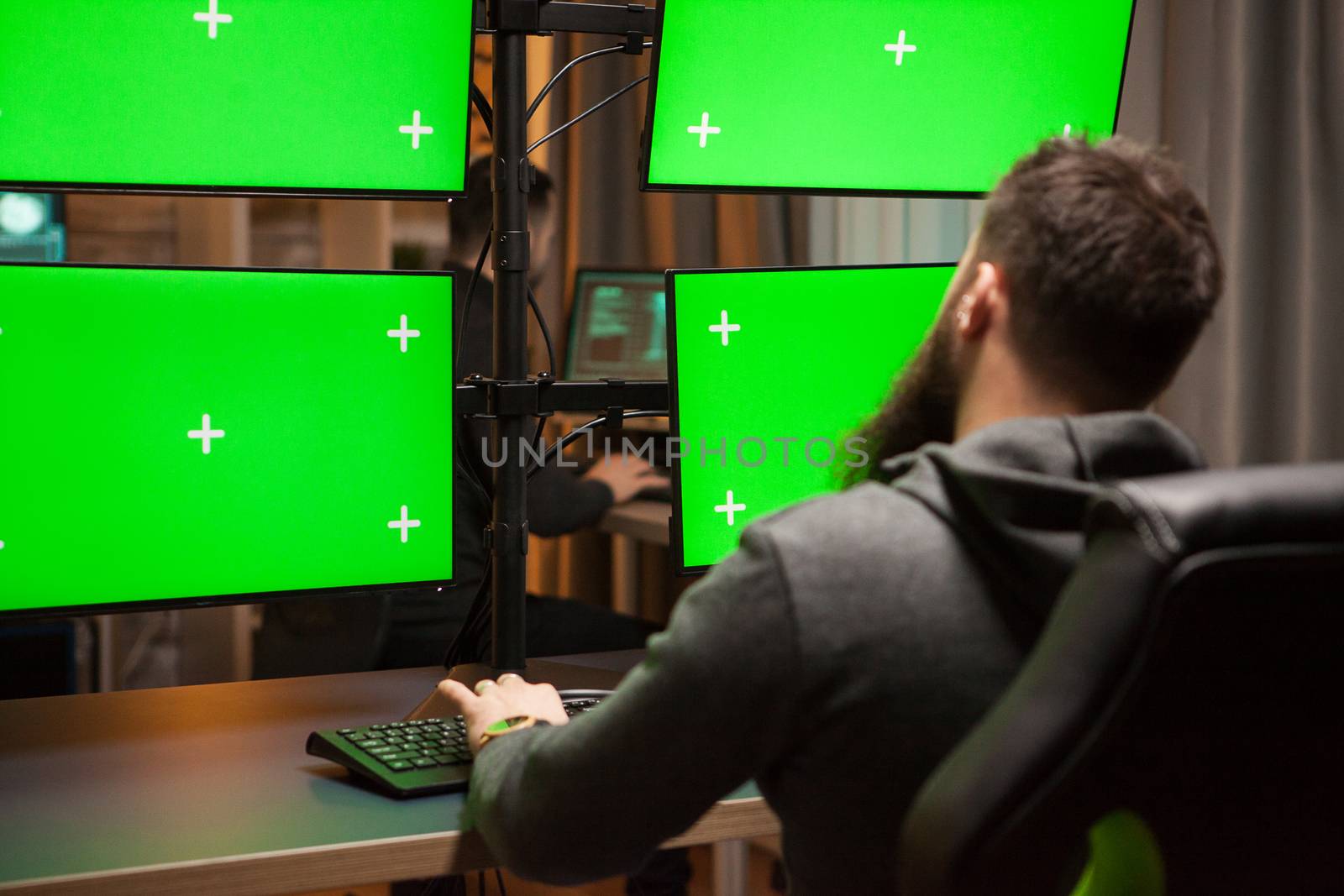 International hacker planning a cyber attack on computer with green chroma key.