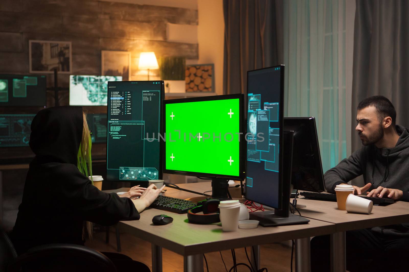 Dangerous female hacker in writing a malware on computer with green screen. Male hacker.