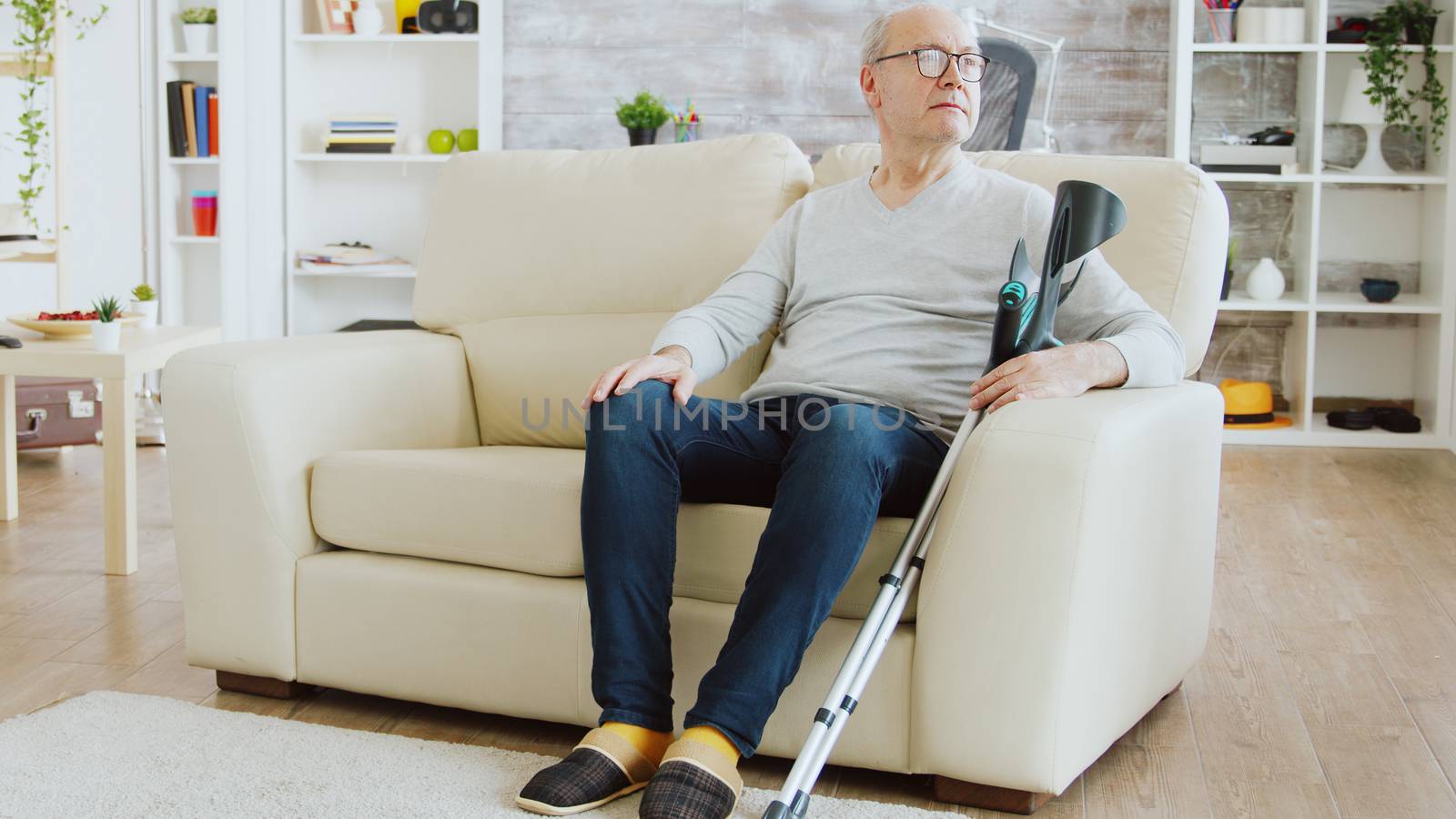 Revealing shot of male nurse checking on retired old man with alzheimer by DCStudio