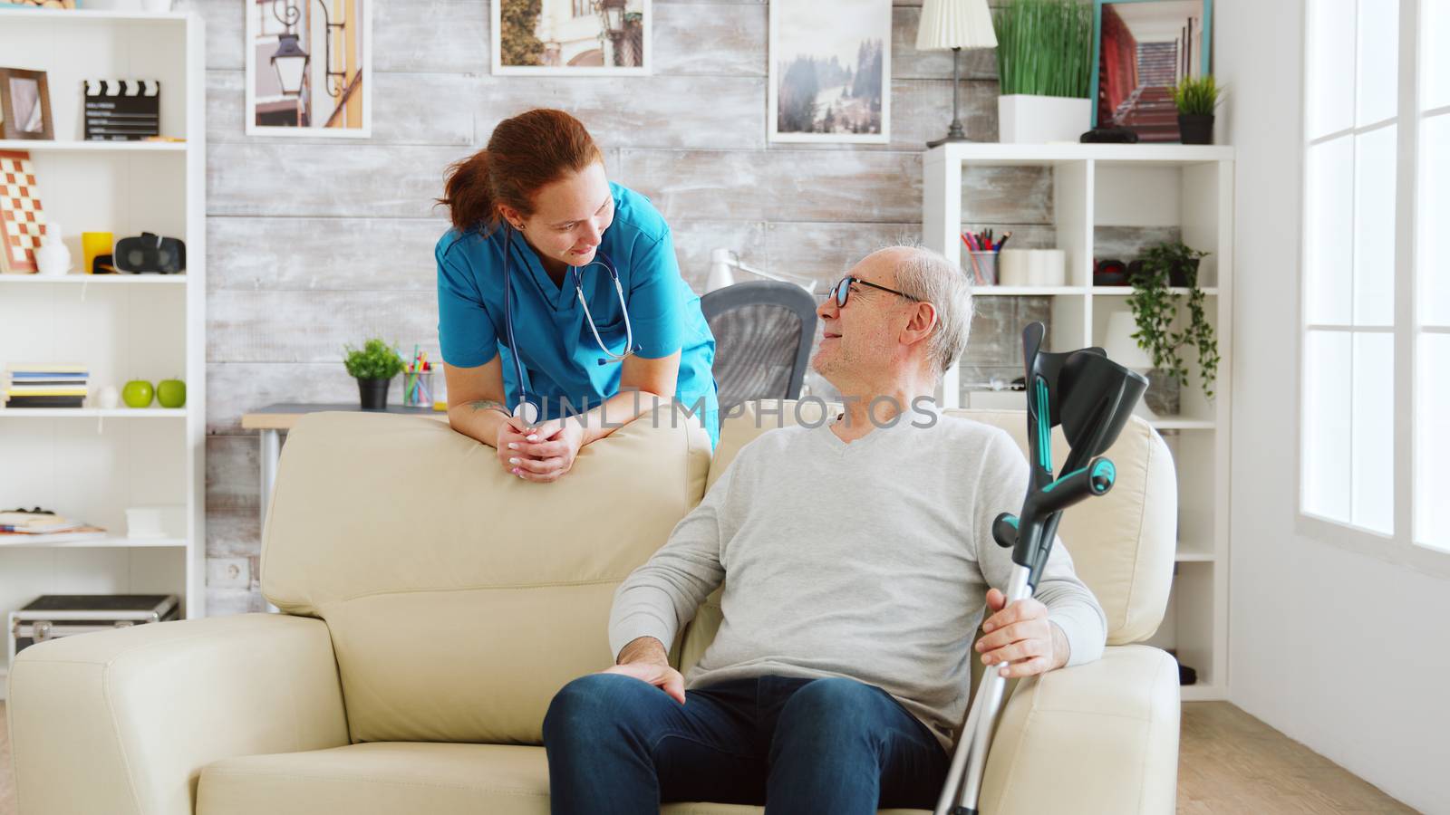 Retired man in nursing home talking with a nurse by DCStudio