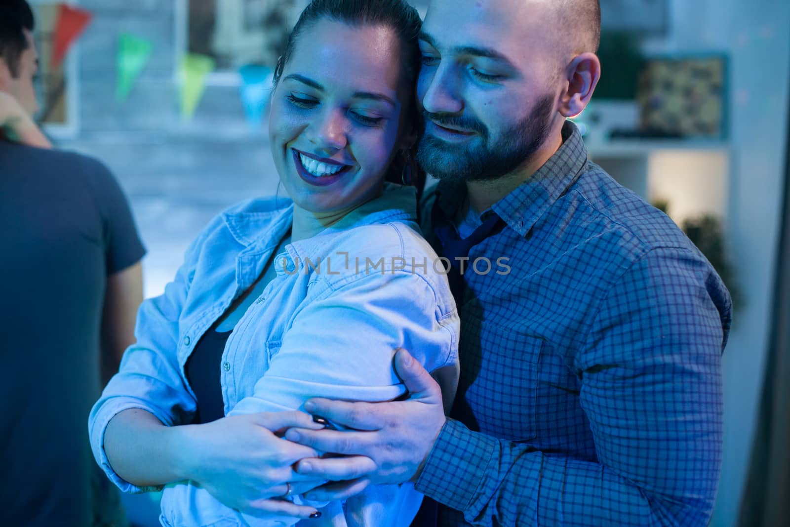 Beautiful young woman having a big smile while dancing with her boyfriend at a party.