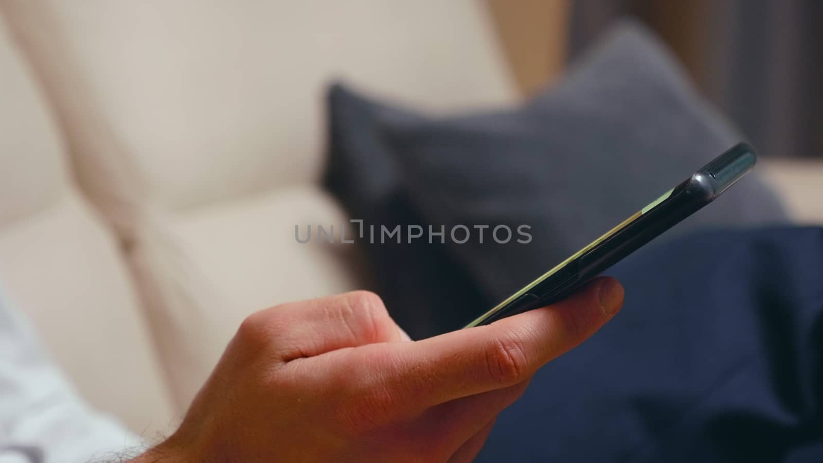 Close up of businessman browsing on smartphone with green screen.