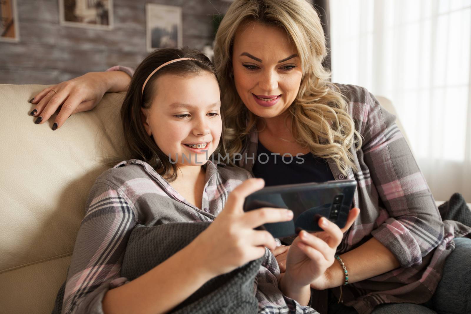 Modern mother and her little daughter with braces recording a call for grandparents.