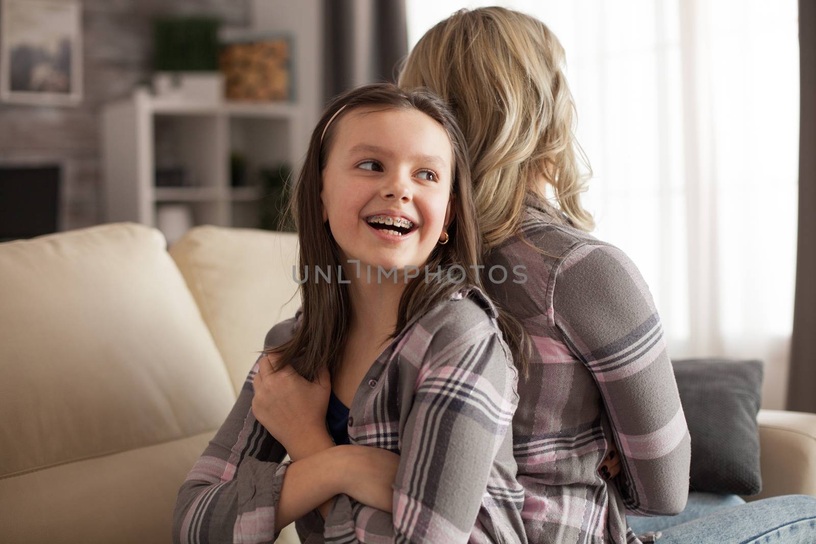 Little girl with a big smile and braces sitting back to back by DCStudio