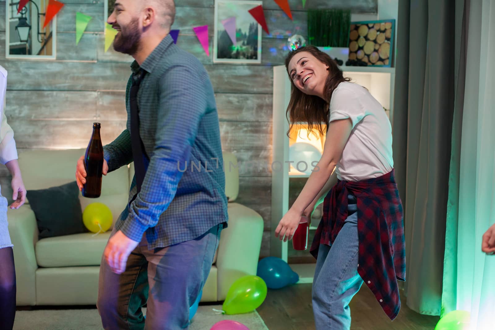 Cheerful beautiful woman smiling while dancing at a party of a friend.