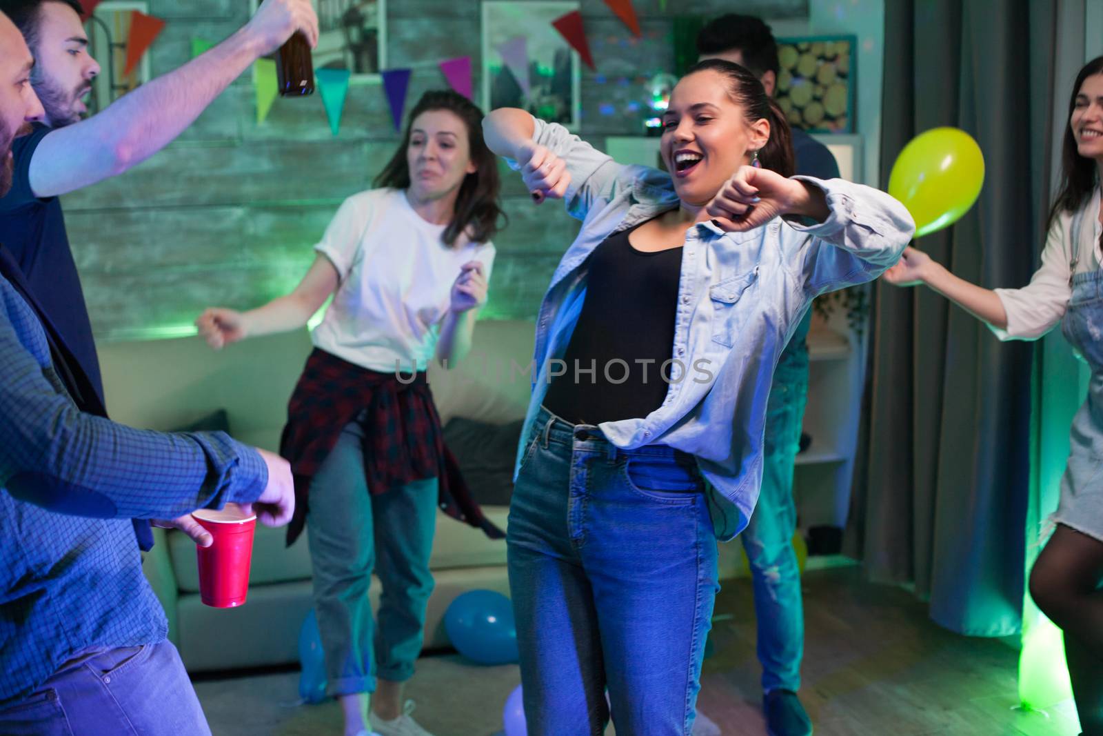 Cheerful young woman having a good time while partying with group of people.