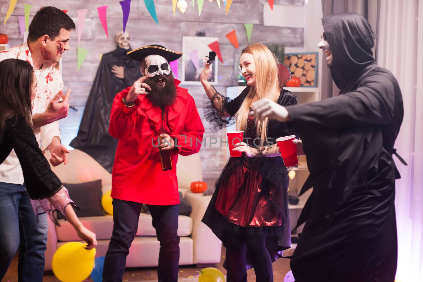 Grim reaper and pirate dancing while celebrating halloween . Spooky costumes.