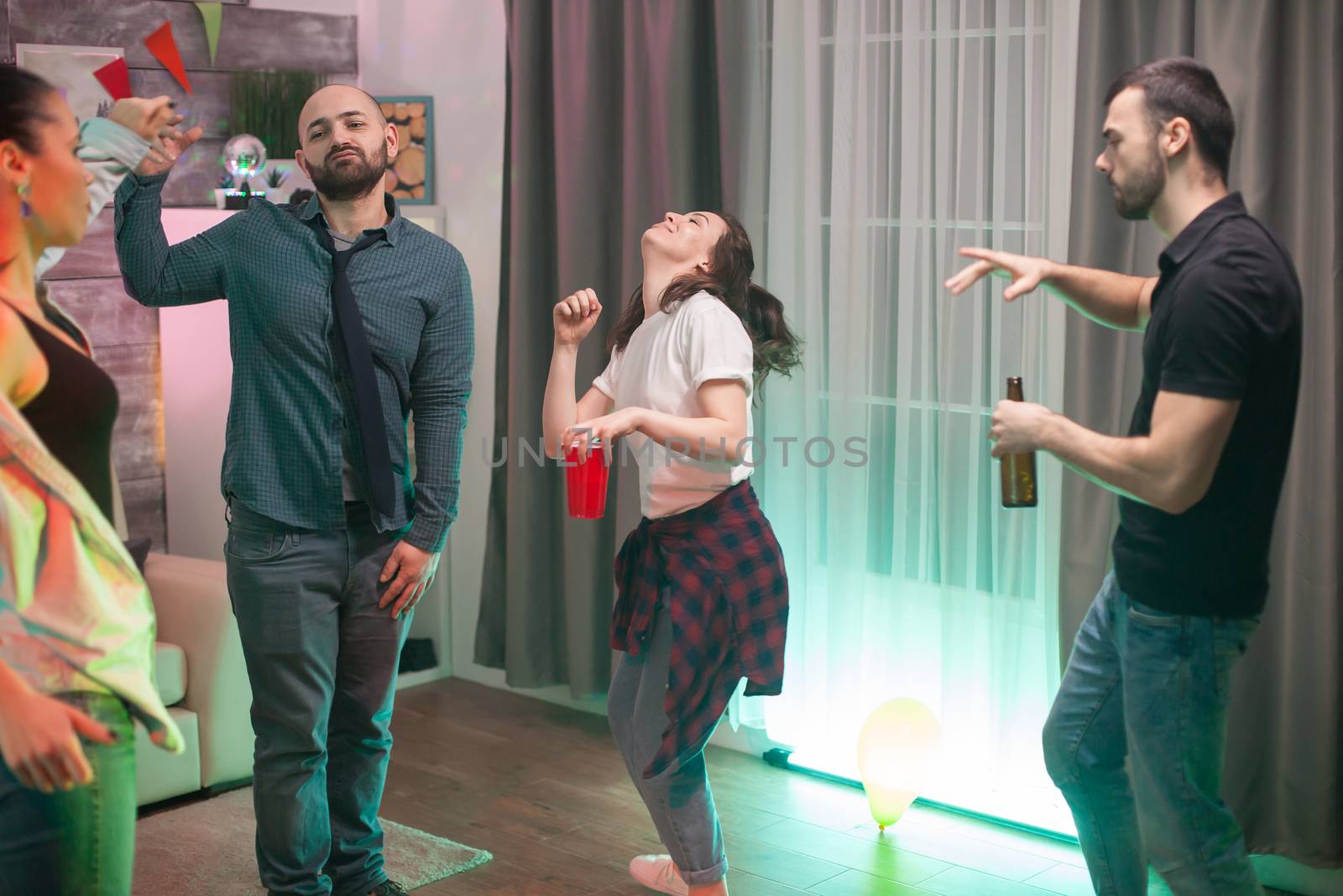 Young people dancing at a party with good music by DCStudio