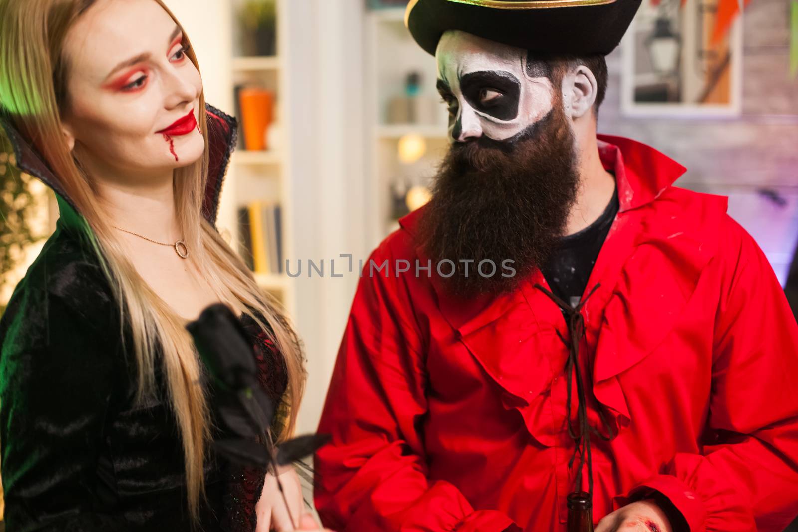 Man dressed up like a pirate trying to seduce vampire woman at halloween party.