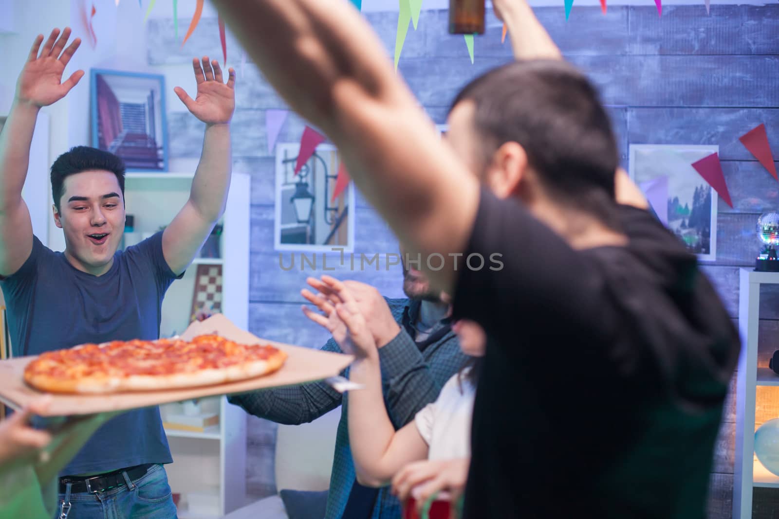 Cheerful group of young people about pizza at the party. Group of young people having fun.