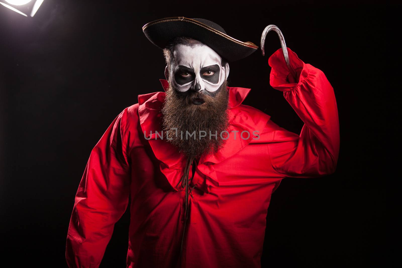 Scary pirate with a hook and long beard over black background. Halloween outfit.