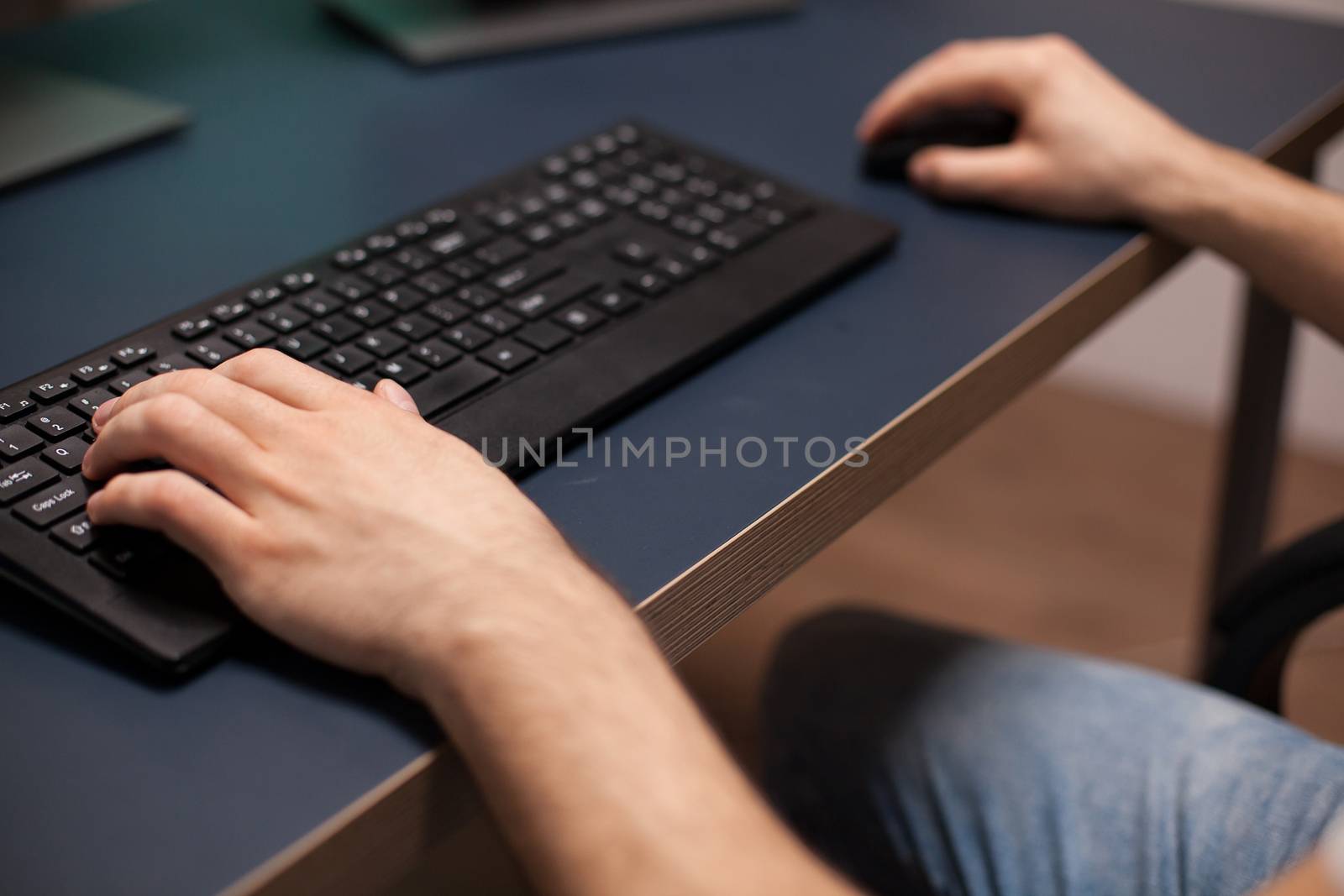 Close up hands shot of gamer using keyboard playing oline video games.
