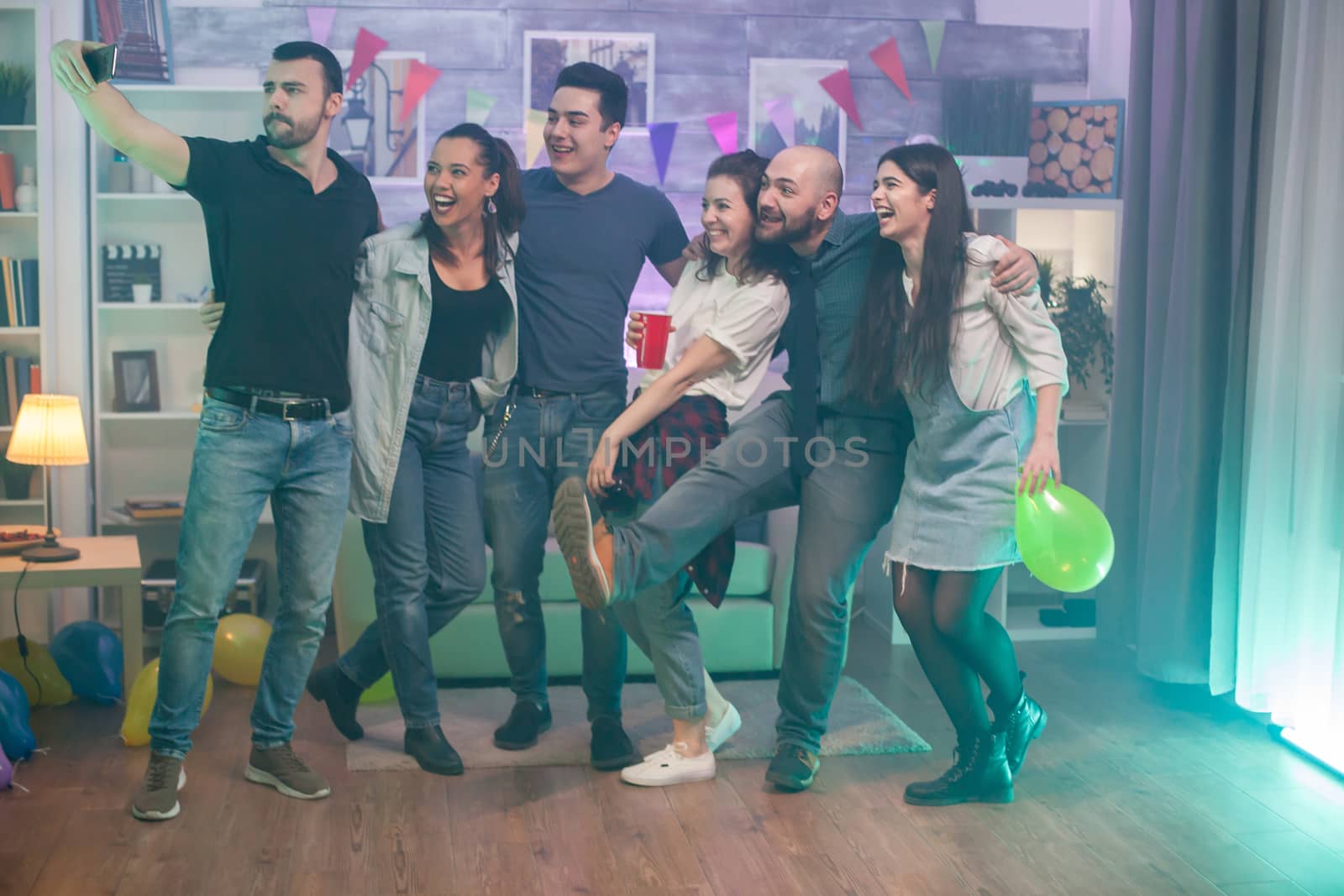 Happy and cheerful young man and women taking a selfie while celebrating their friendship.