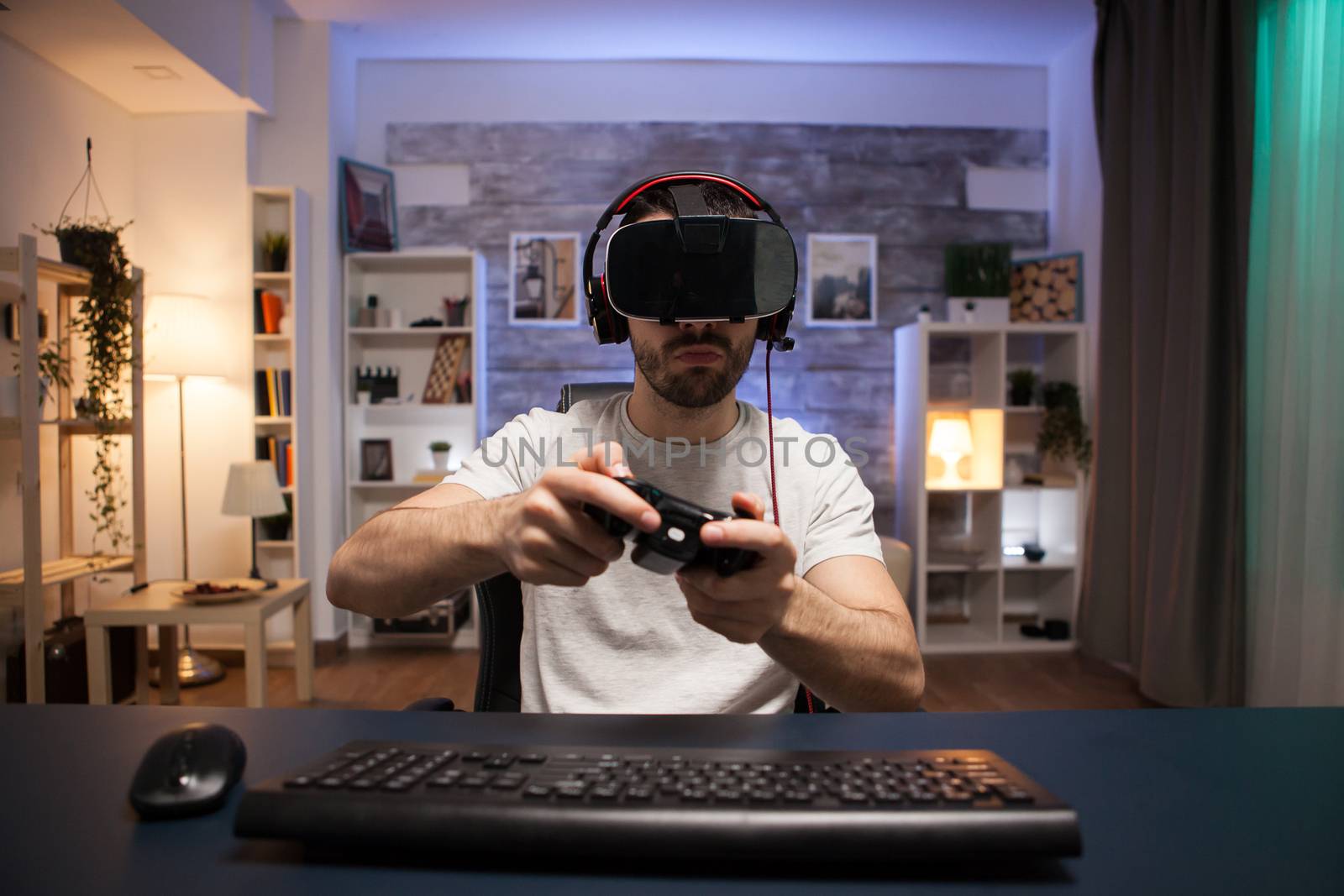Pov of online shooter gamer wearing virtual reality goggles while using wireless controller.