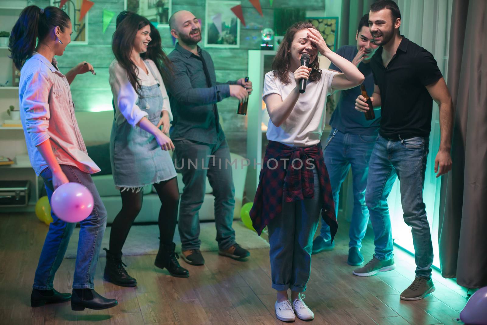 Young woman can't believe she's doing karaoke at her friends party.