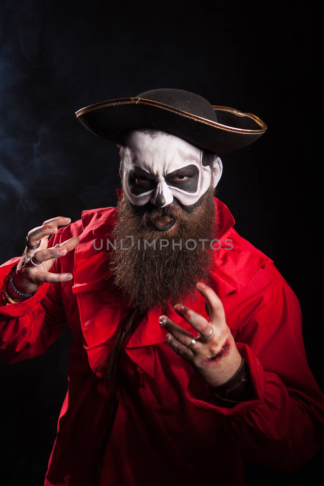 Actor with long beard and hat dressed up like a pirate over black background. Halloween costume.