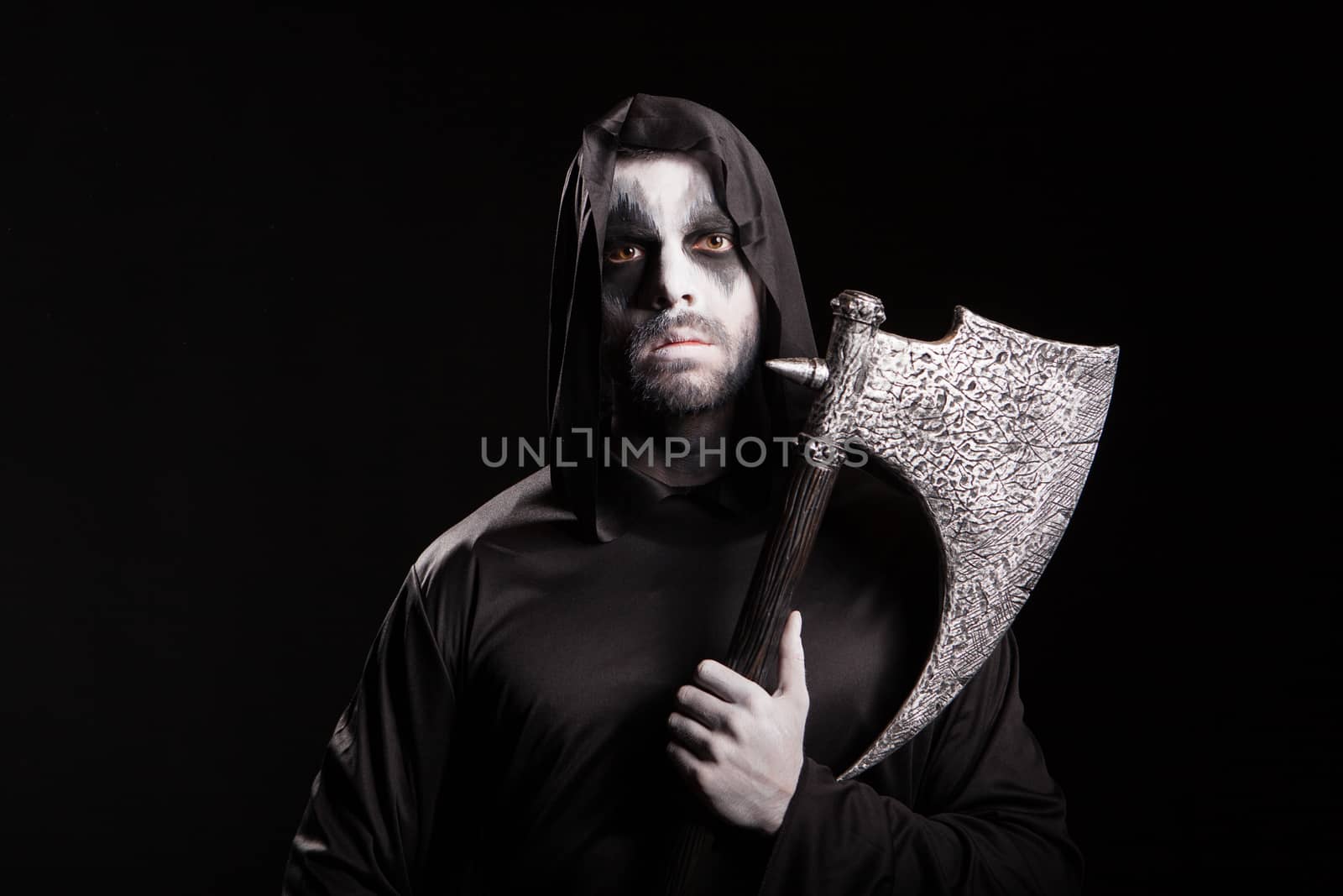 Evil grim reaper with an axe over black background for halloween.