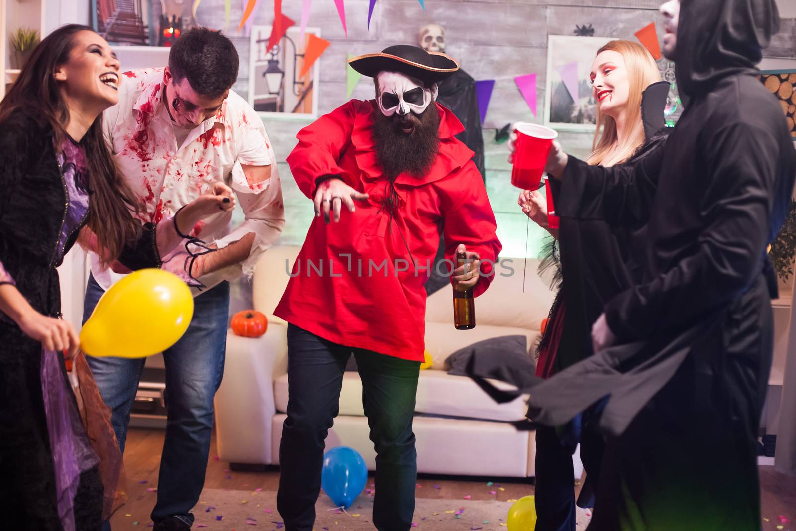 Man dressed up like a pirate dancing around his friends celebrating halloween.