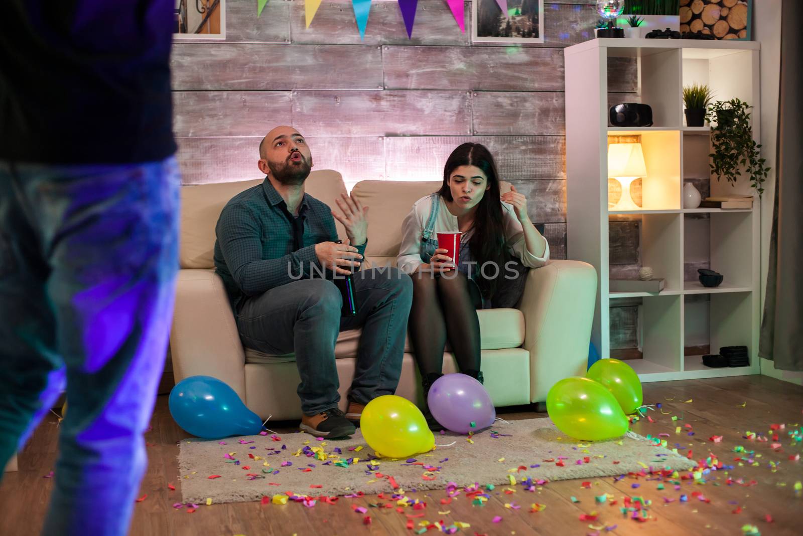 Young couple at a party after drinking too much beer having a fight.