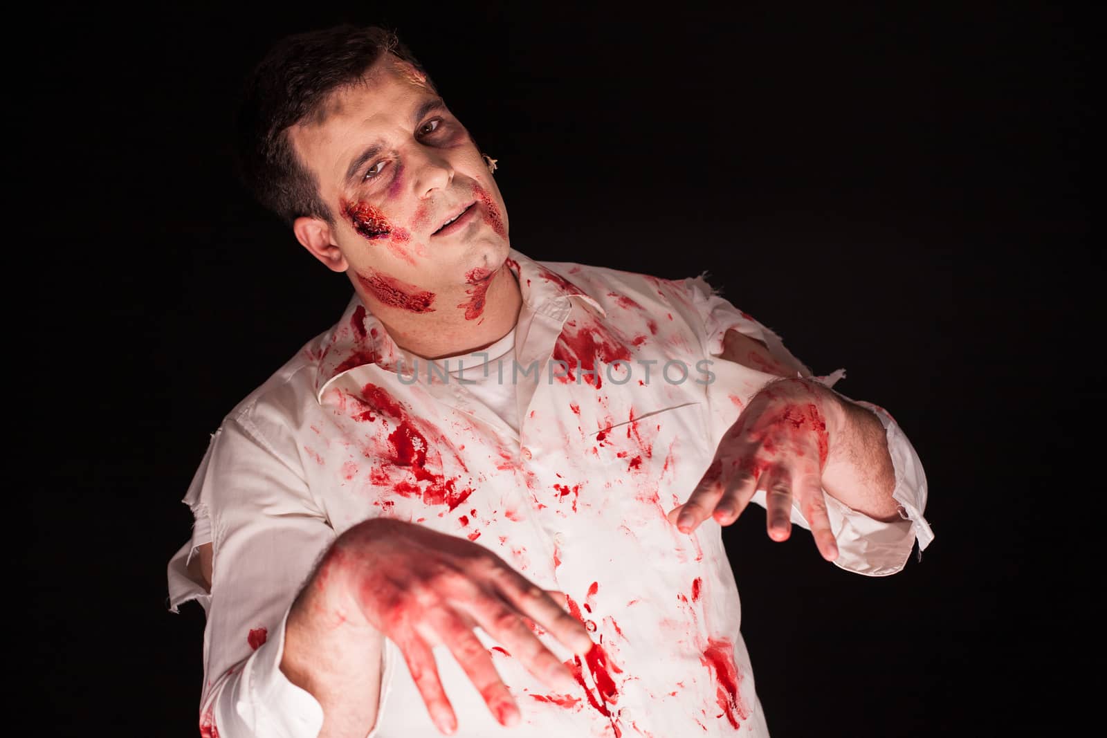 Violent zombie with bloody creative make up over black background. Dead man.
