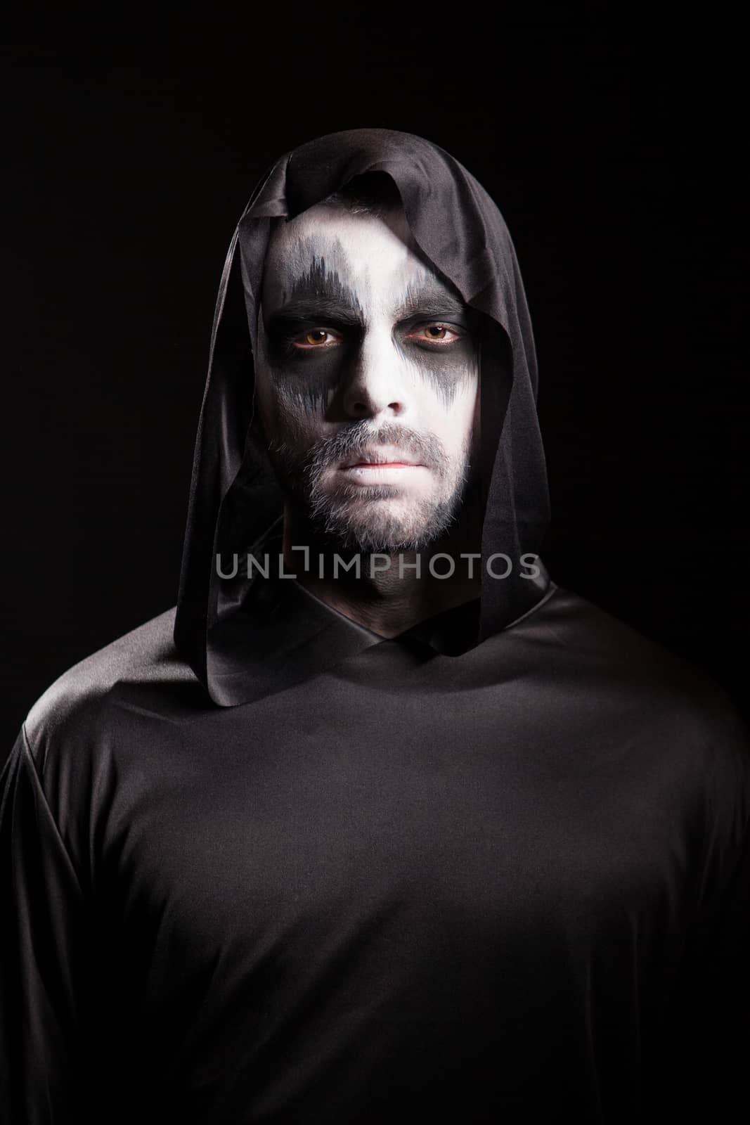 Grim reaper with a hood isolated over black background by DCStudio