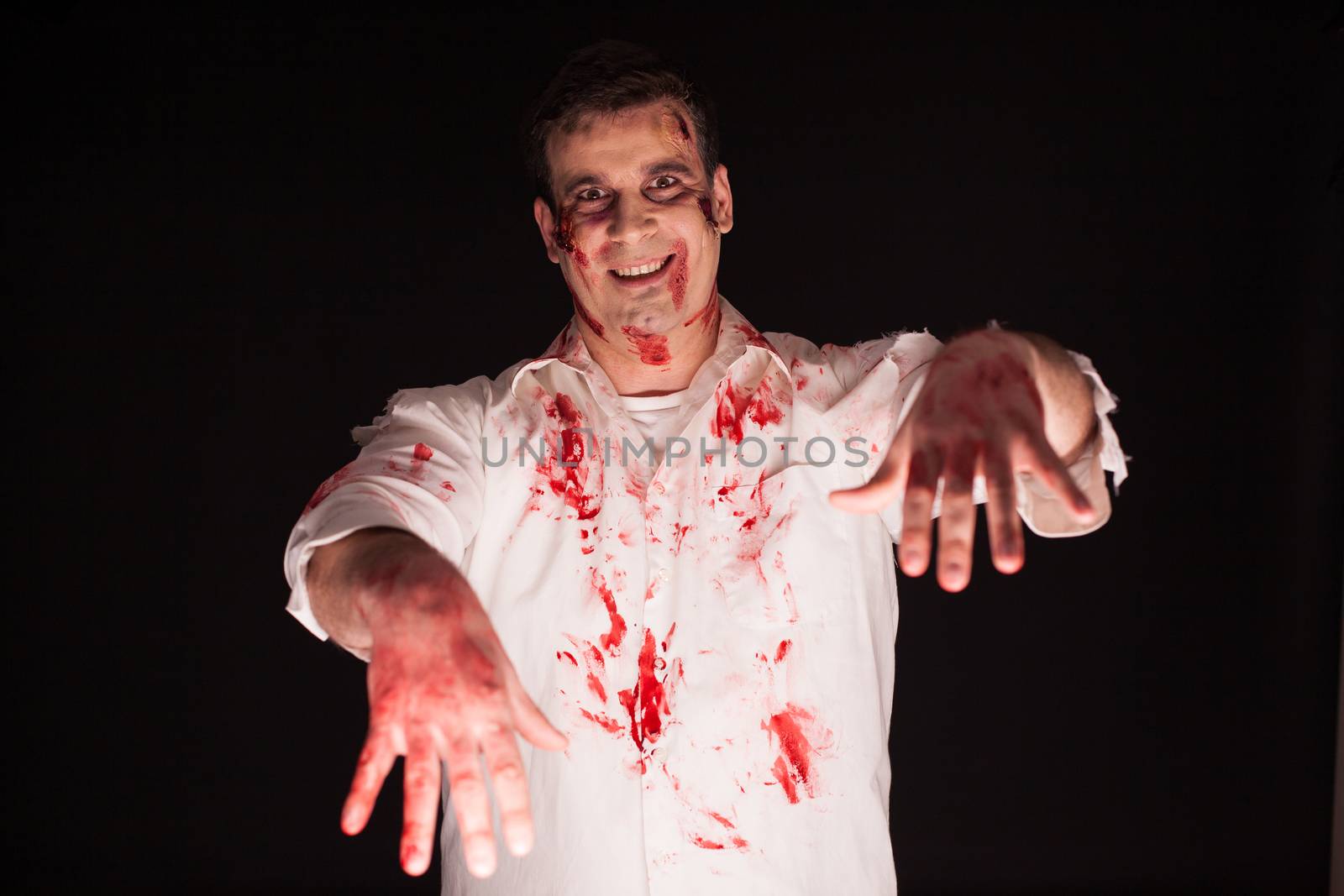 Spooky death demon with blood over black background. Halloween costume.