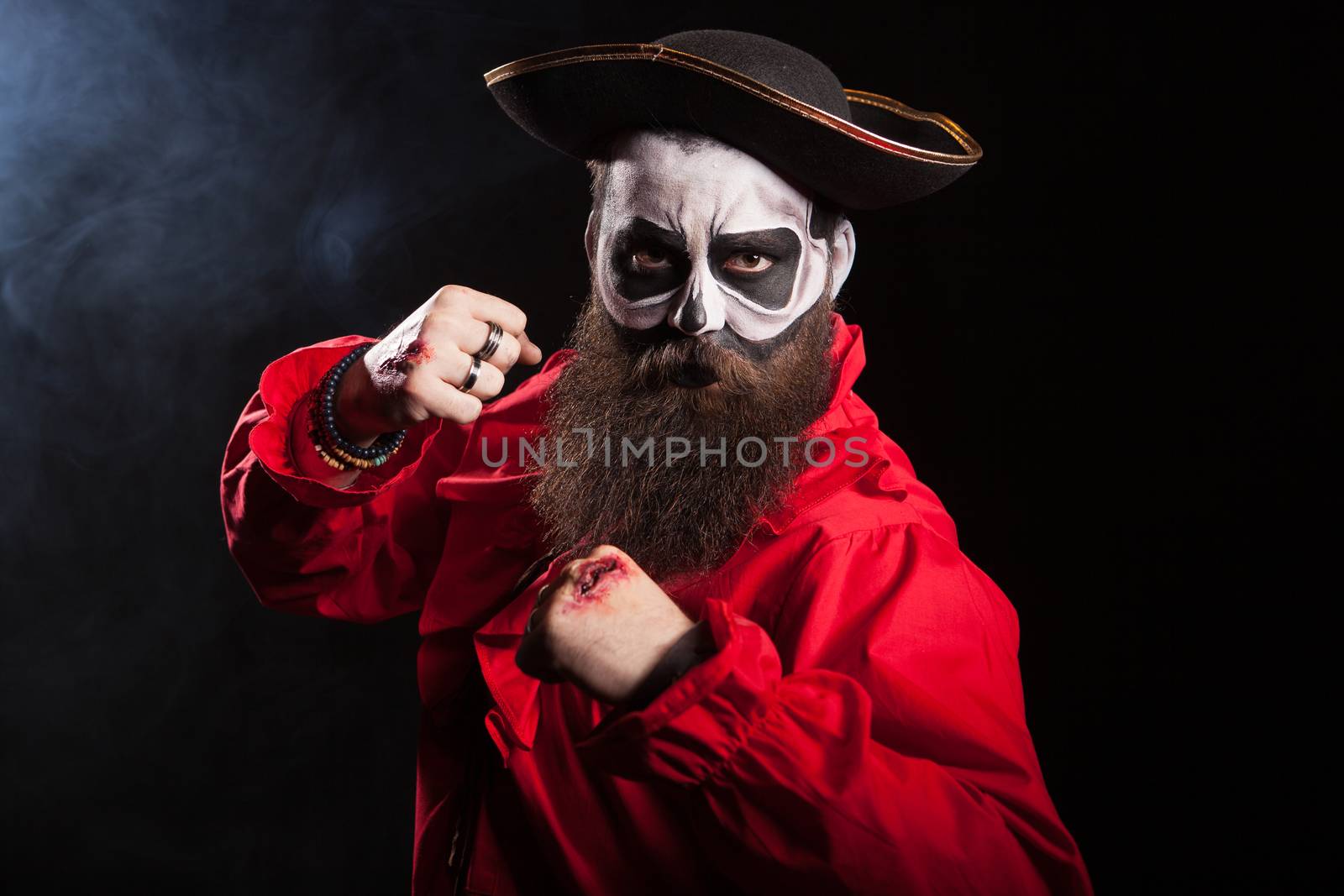 Scary pirate with fists up isolated over black background by DCStudio