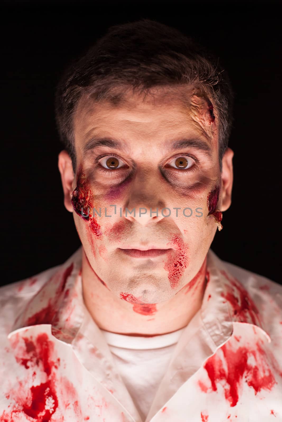 Close up of bloody zombie over black background for halloween. Creative makeup.