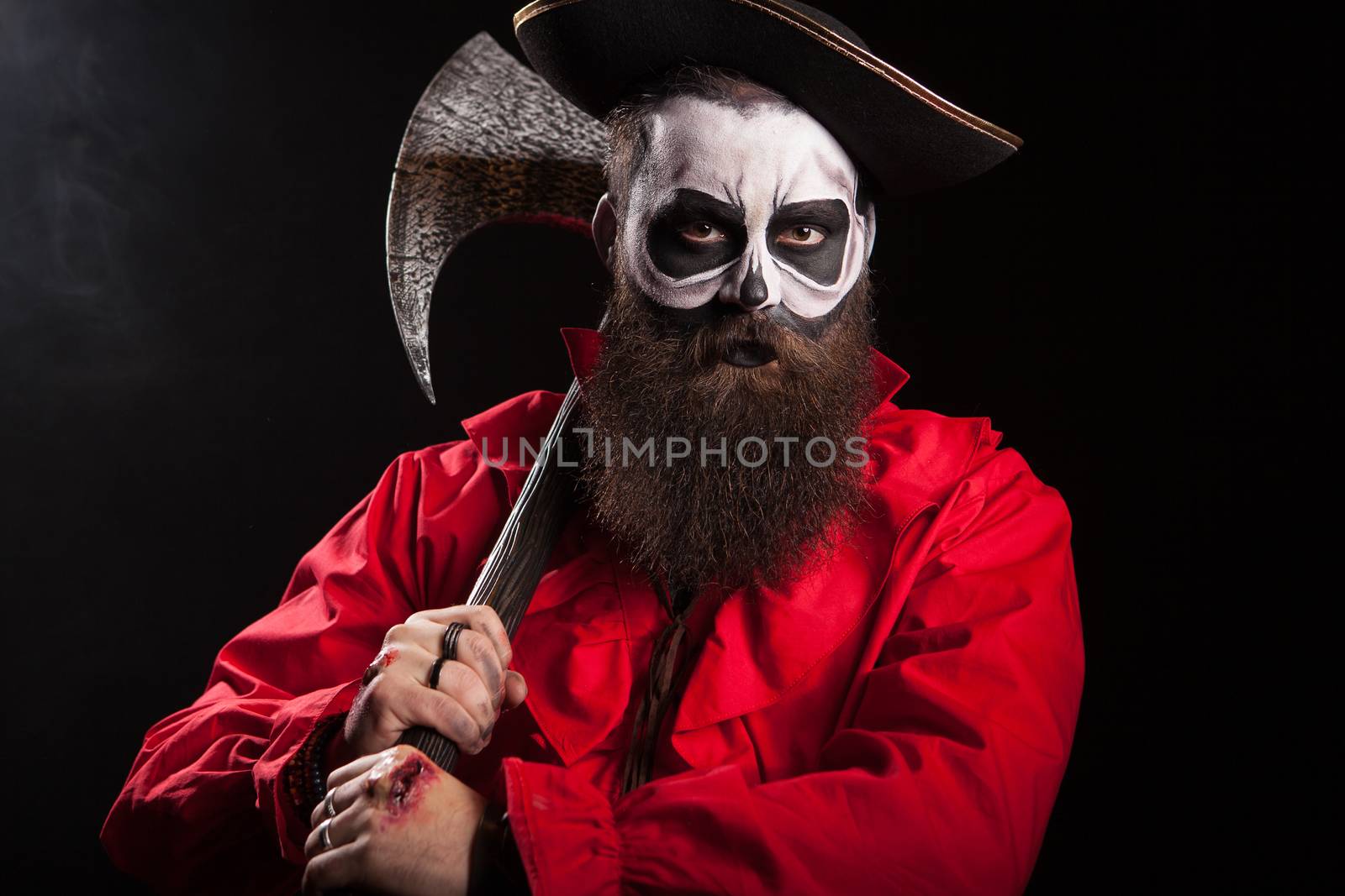 Medieval captain holding an axe over black background. Halloween outfit.