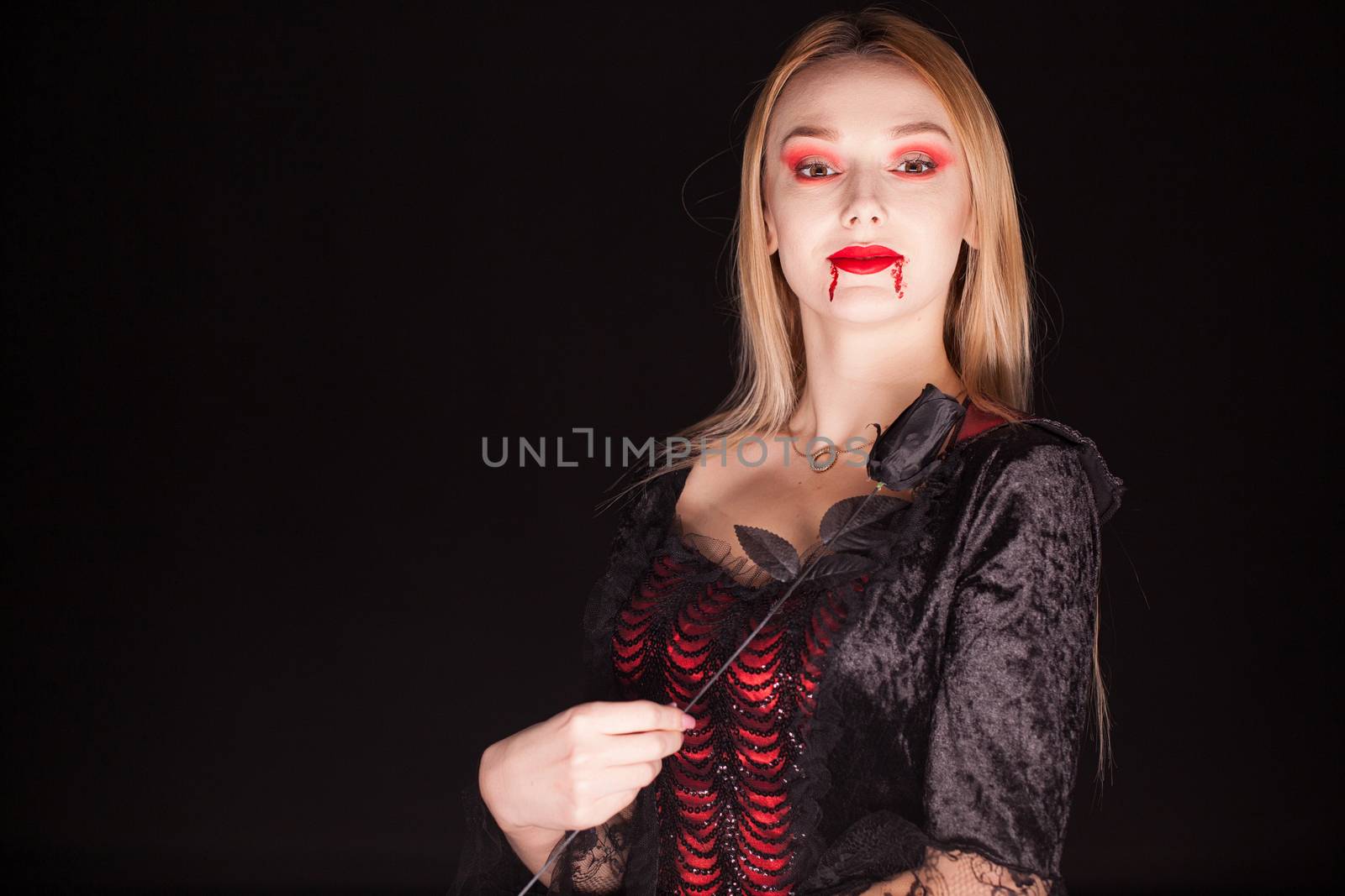 Woman wearing a vampire costume with a rose by DCStudio