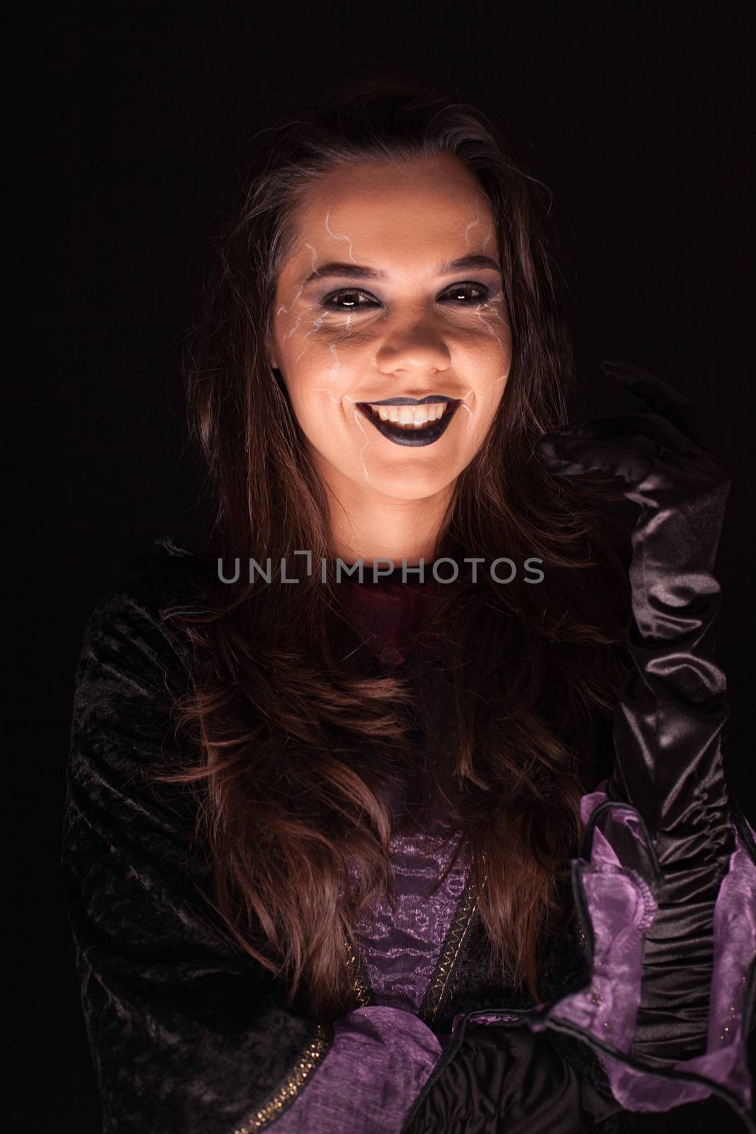 Young woman with a witch outfit for halloween over black background