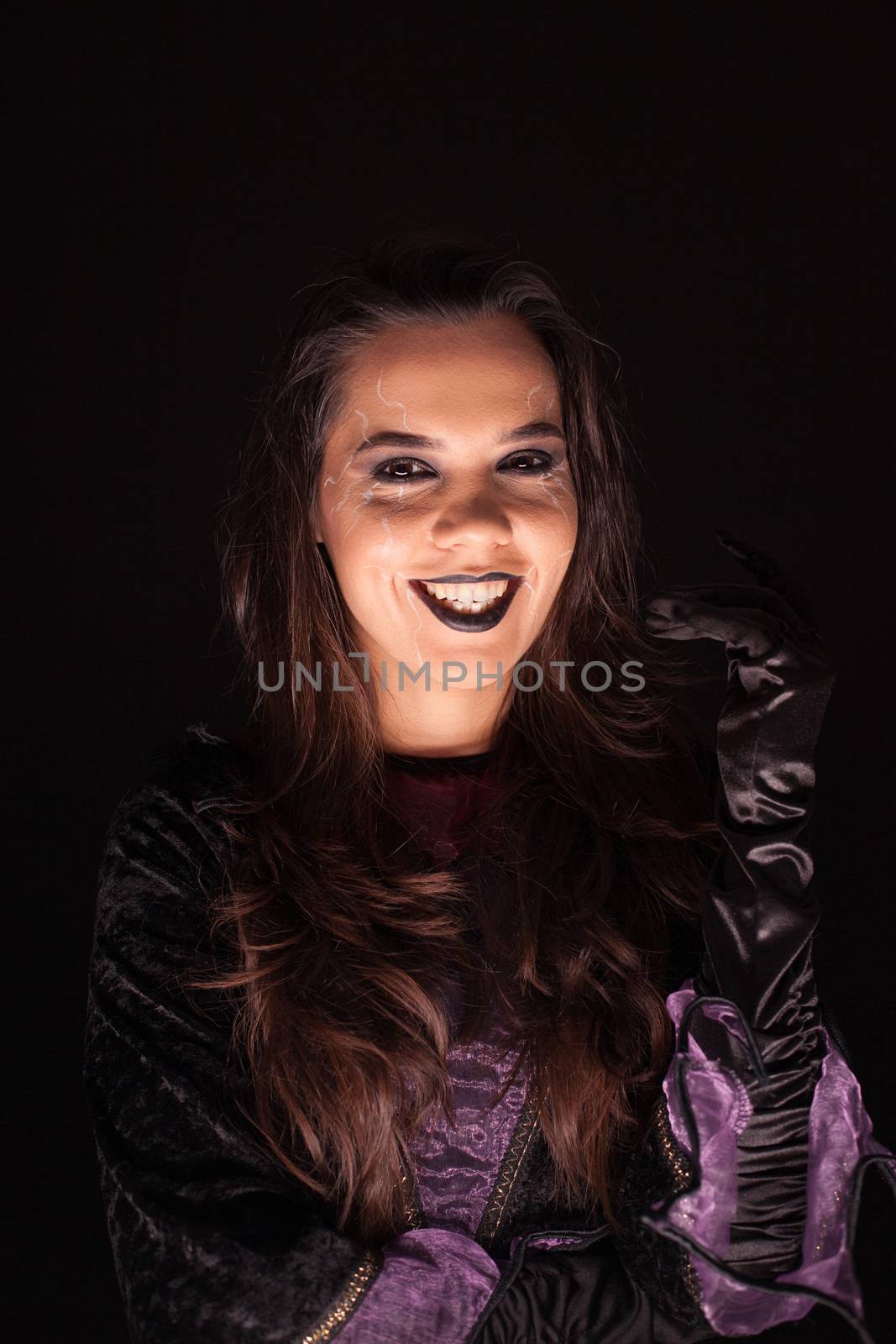 Beautiful woman dressed up like a witch having a scary smile by DCStudio