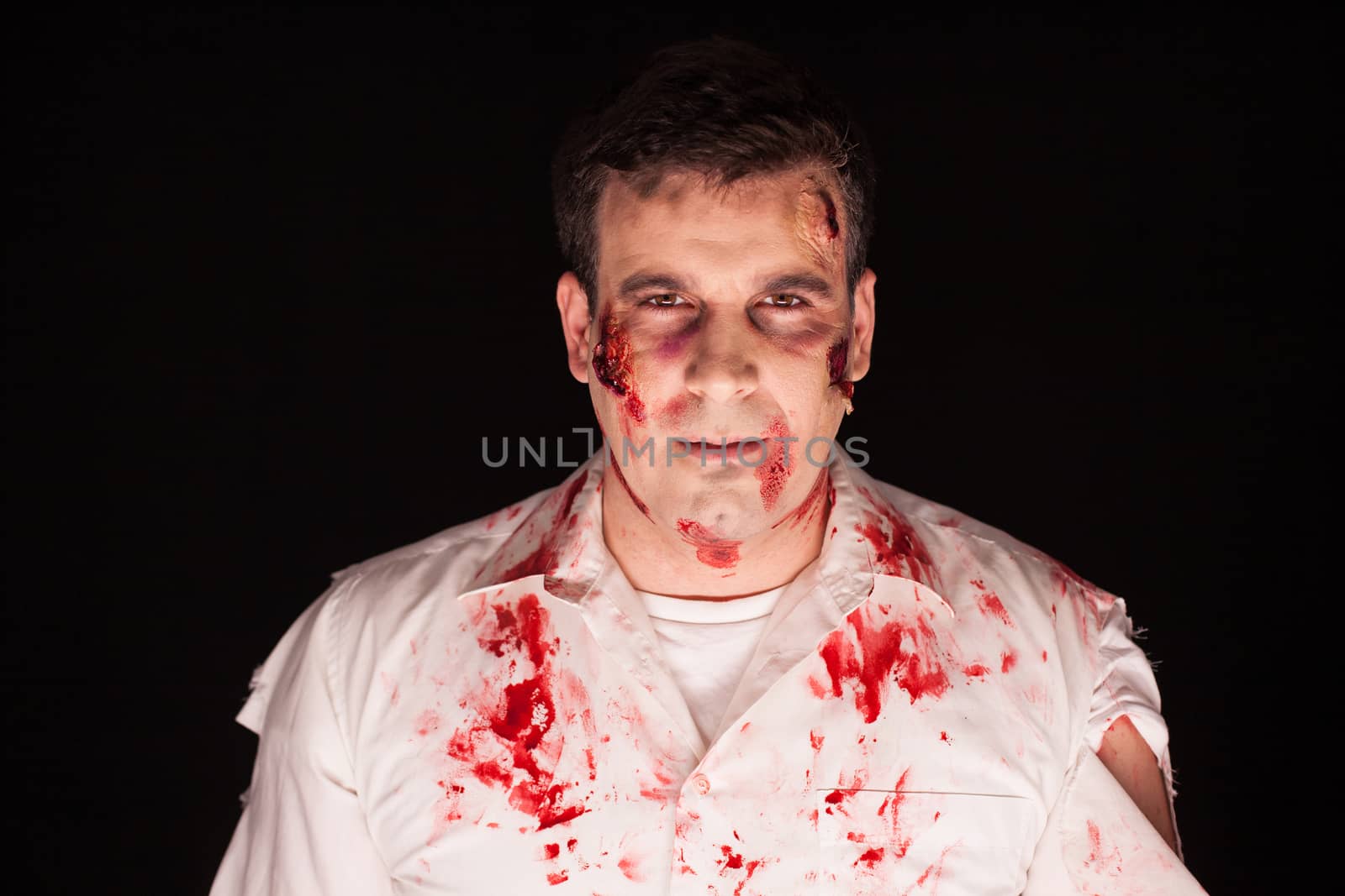 Man dressed up like a zombie for halloween over black background.