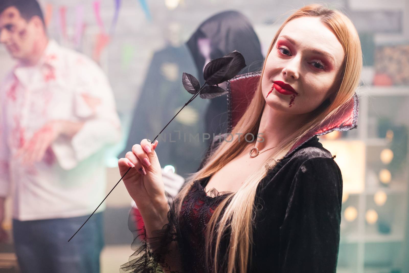 Woman wearing a vampire costume looking at the camera for halloween celebration.