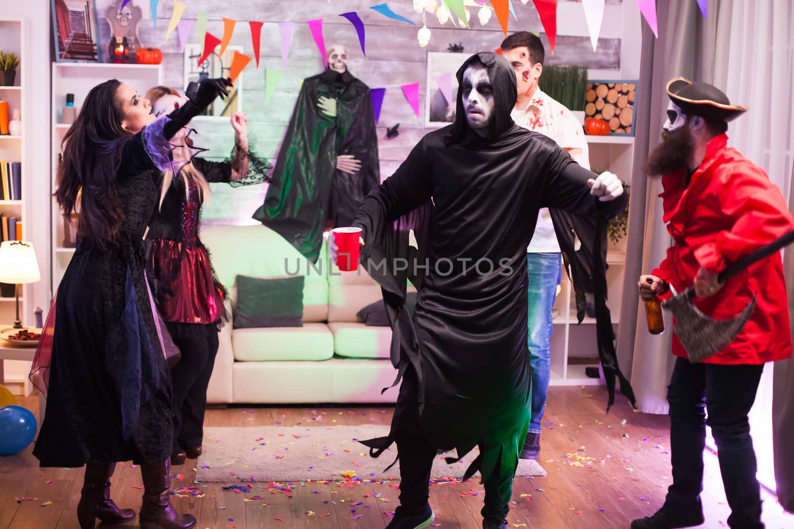 Cheerful man dressed up like a grim reaper with dancing moves by DCStudio