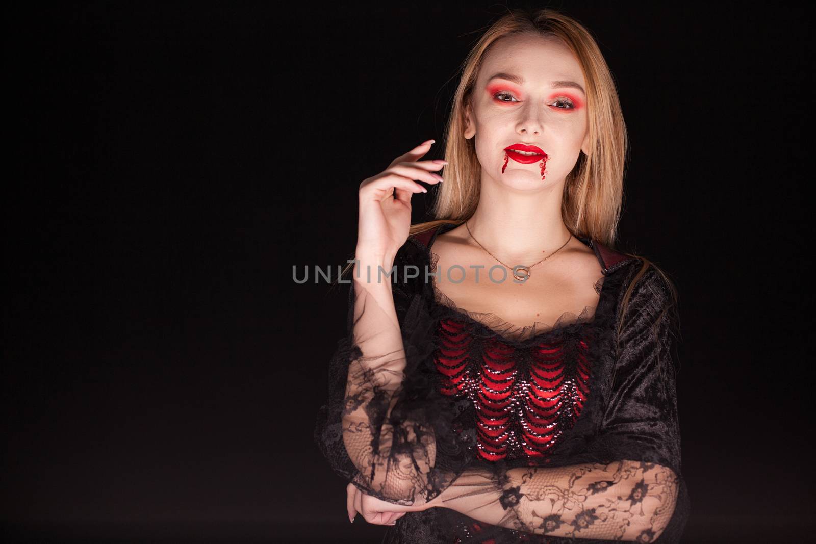 Caucasian woman wearing a seductive vampire costume by DCStudio