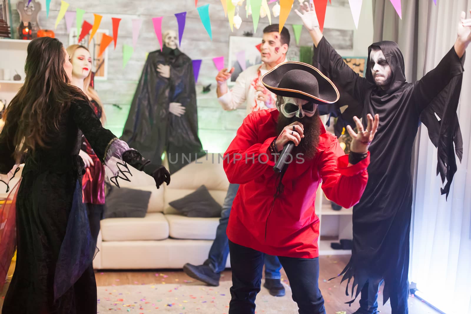 Group of friends enjoying the singing of pirate man at halloween celebration.