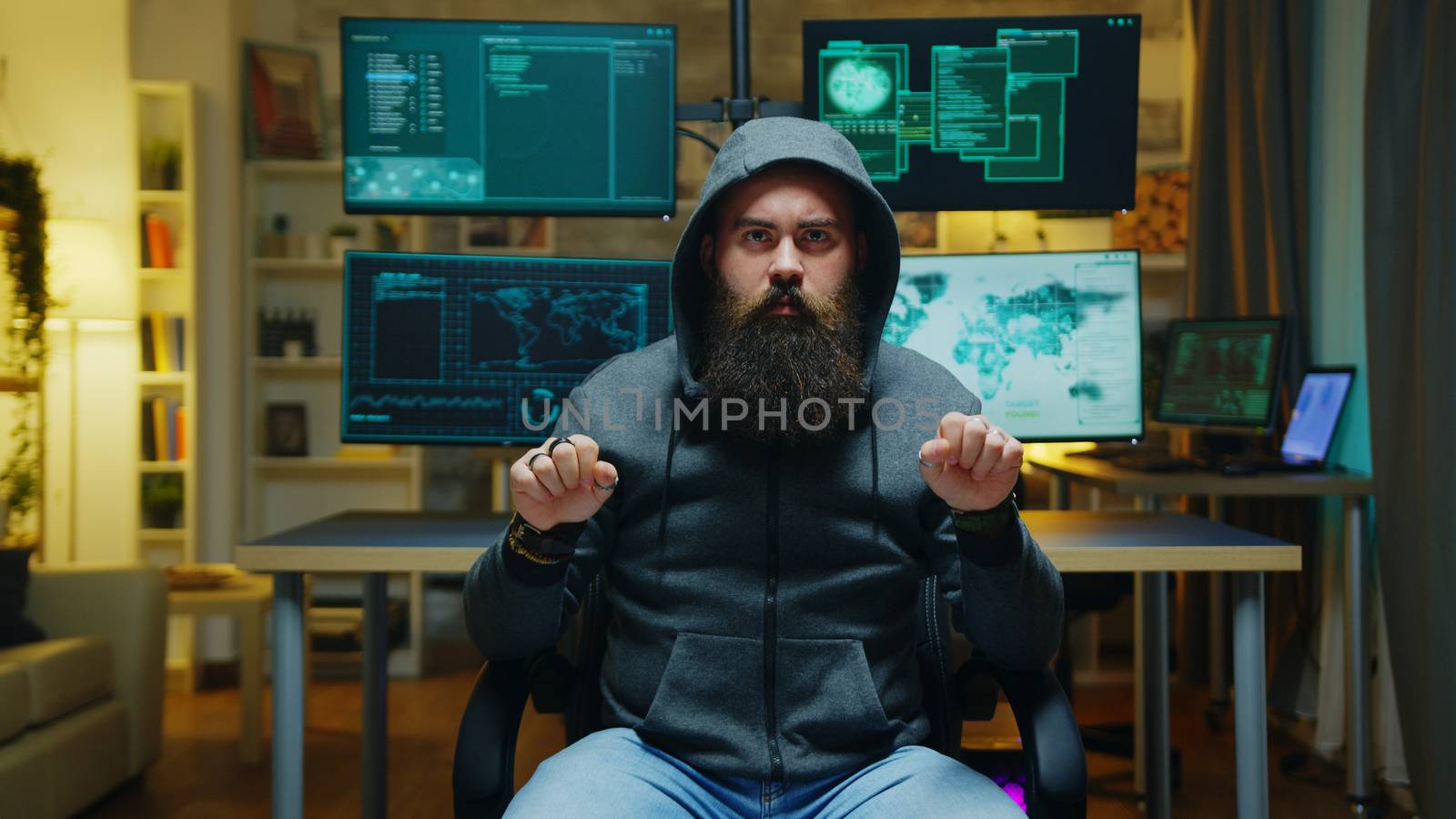 Bearded hacker wearing a hoodie using augmented technology to break government firewall.