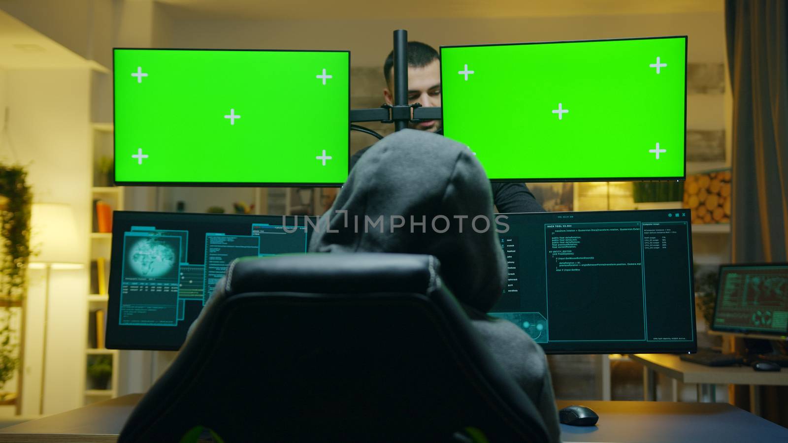 Team of hackers using computer with green screen mockup to steal secret information from the government.