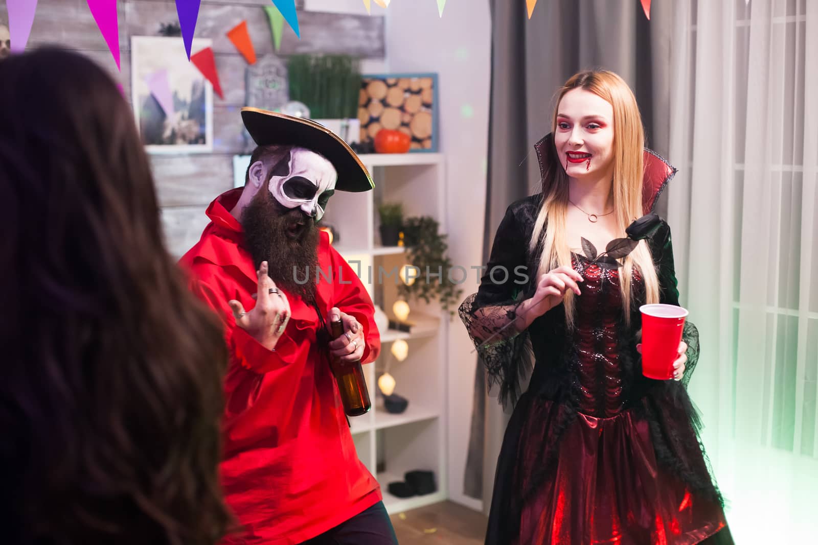 Man dressed up like a pirate singing at halloween celebration with his friends.