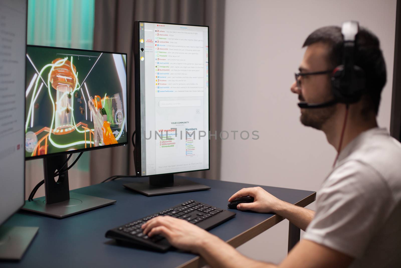 Cheerful young man in his room playing online video games by DCStudio