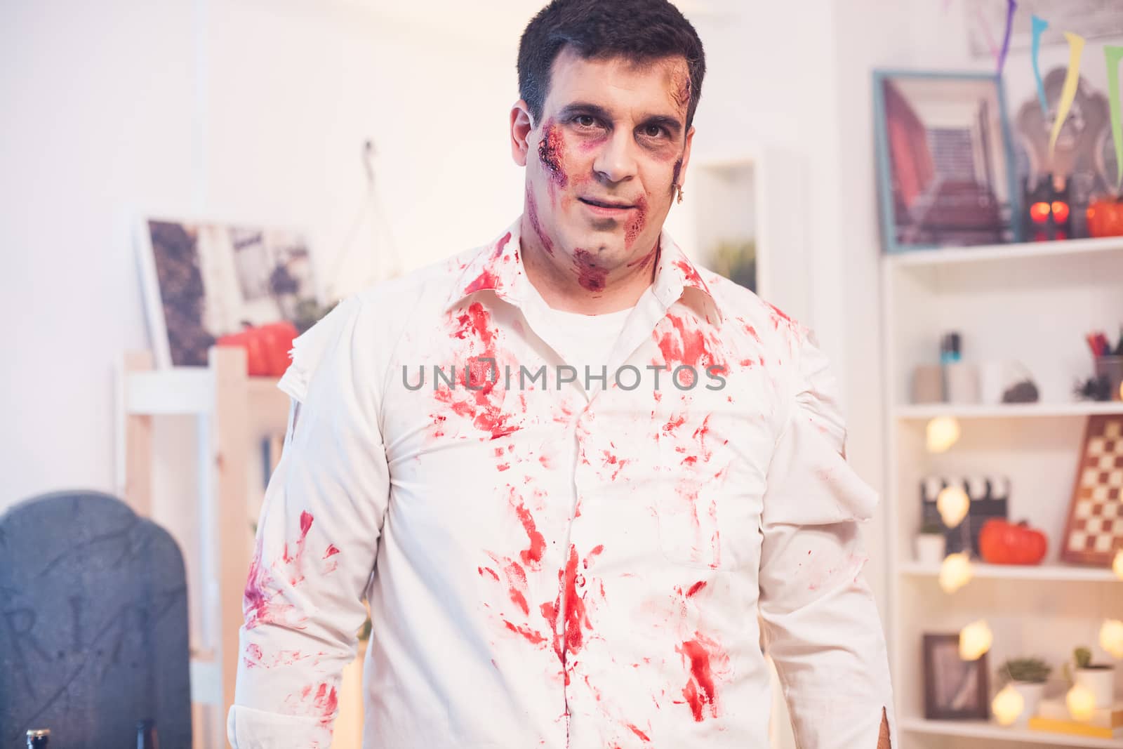 Portrait of man with a zombie costume at halloween celebration looking at the camera.