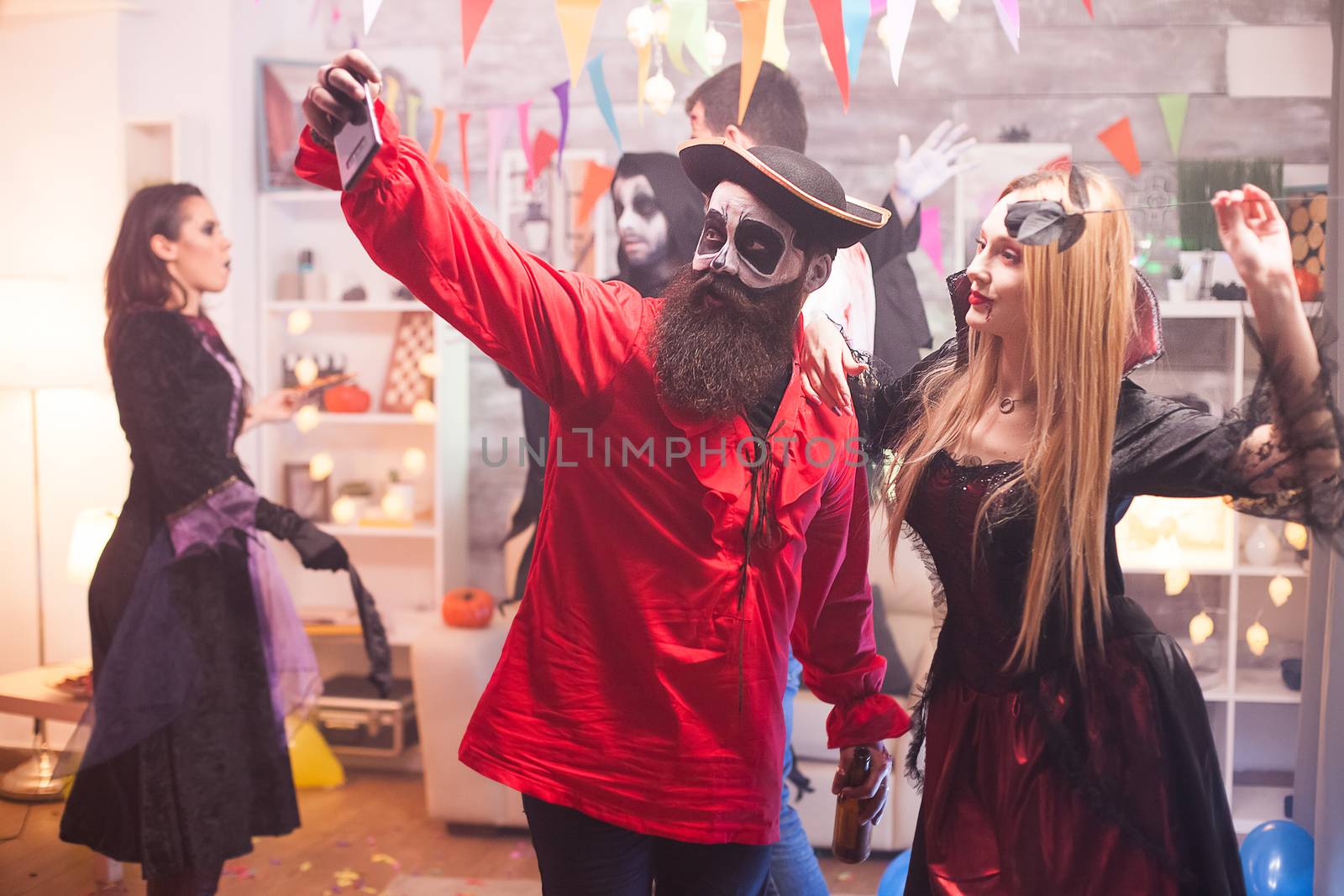 Beautiful young man and woman in halloween costumes taking a selfie.