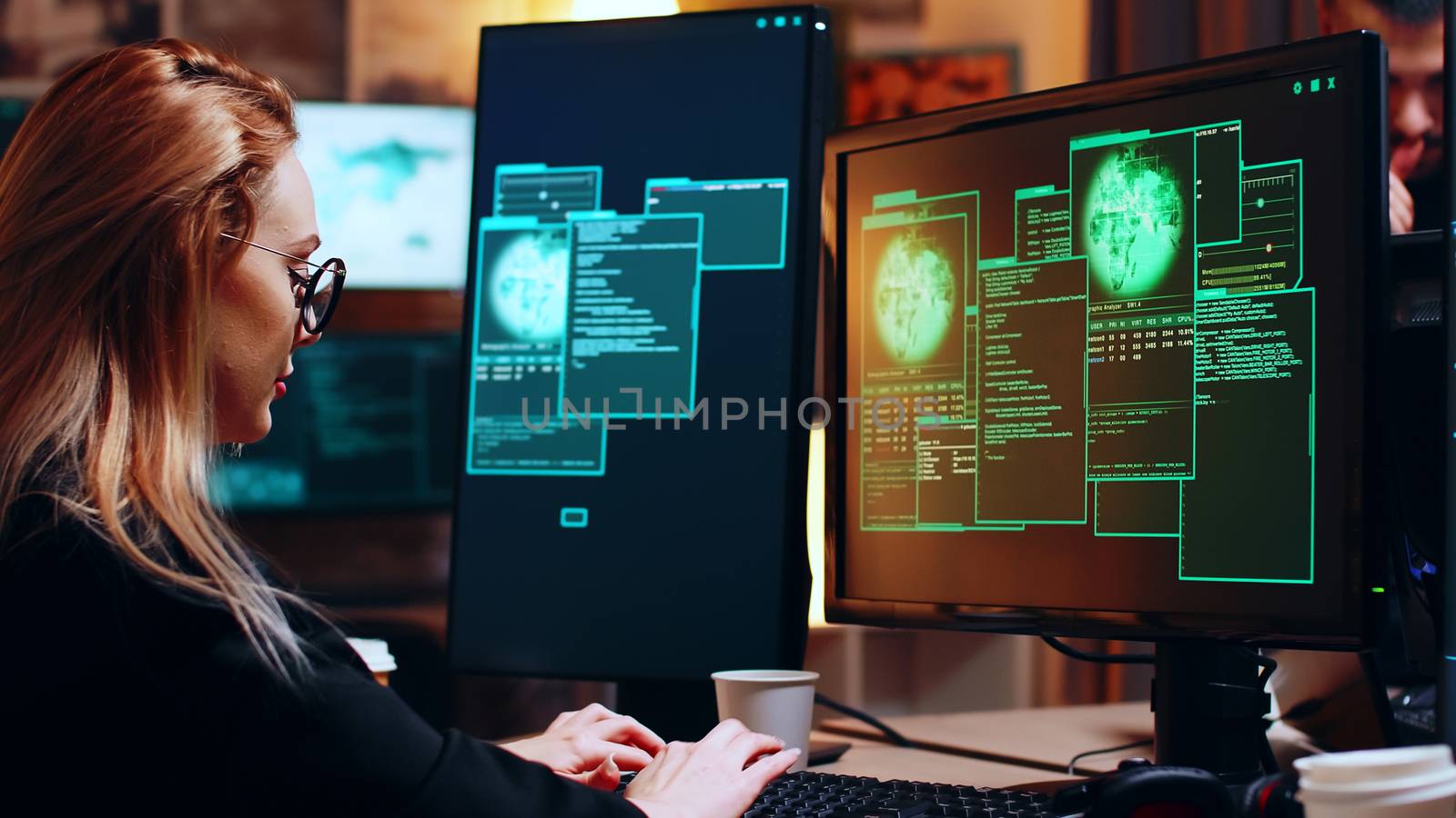 Girl hacker looking at super computer with multiple monitors by DCStudio