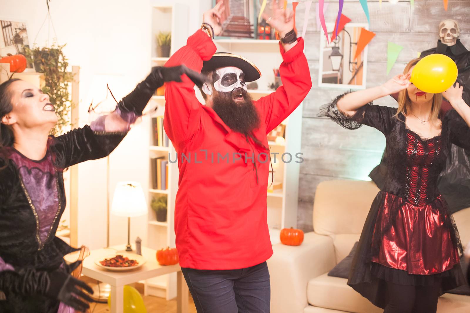 Man dressed up like bearded pirate dancing with hands up while celebrating halloween.