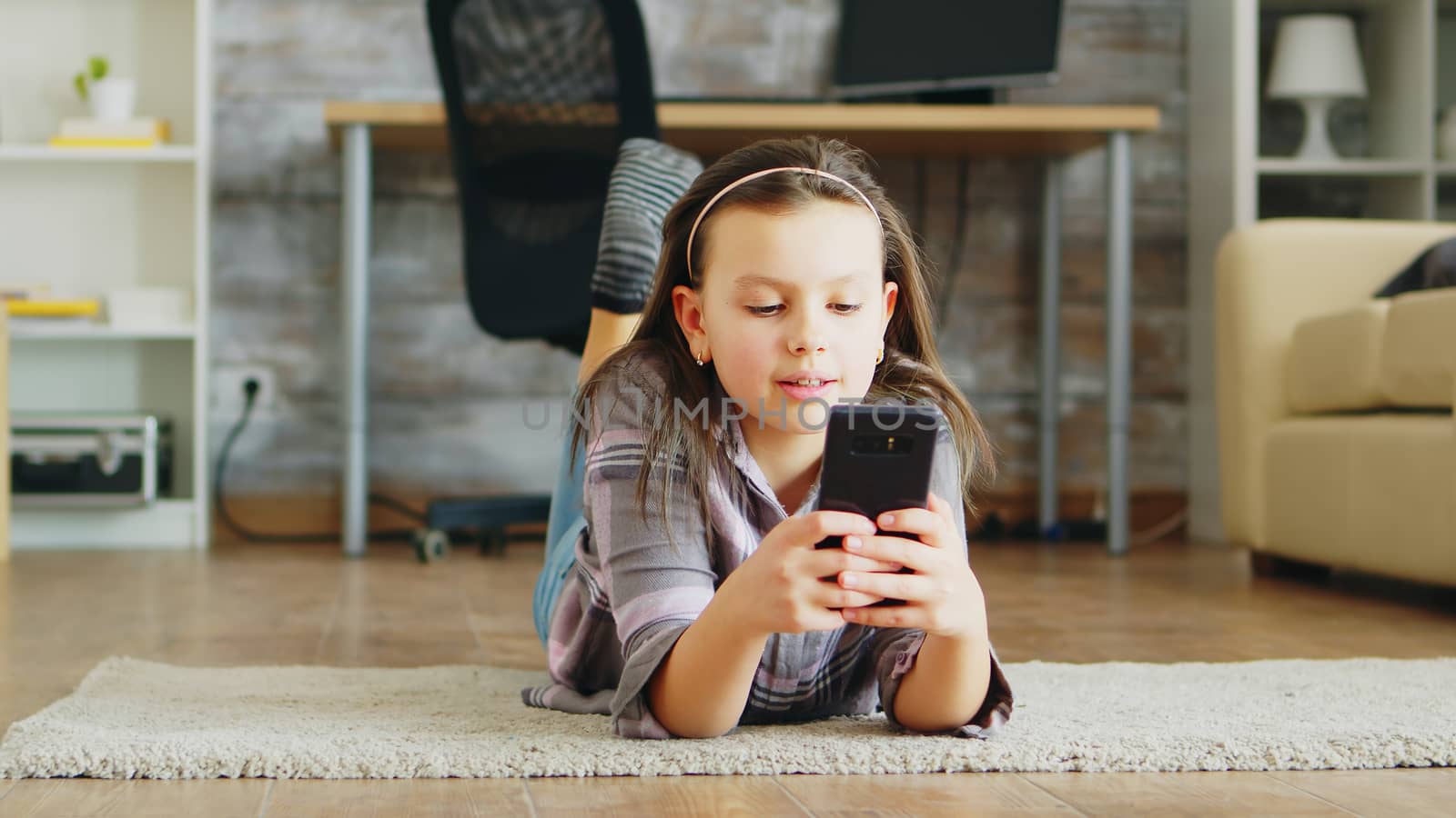 Cheerful little girl lying on the floor carpet by DCStudio