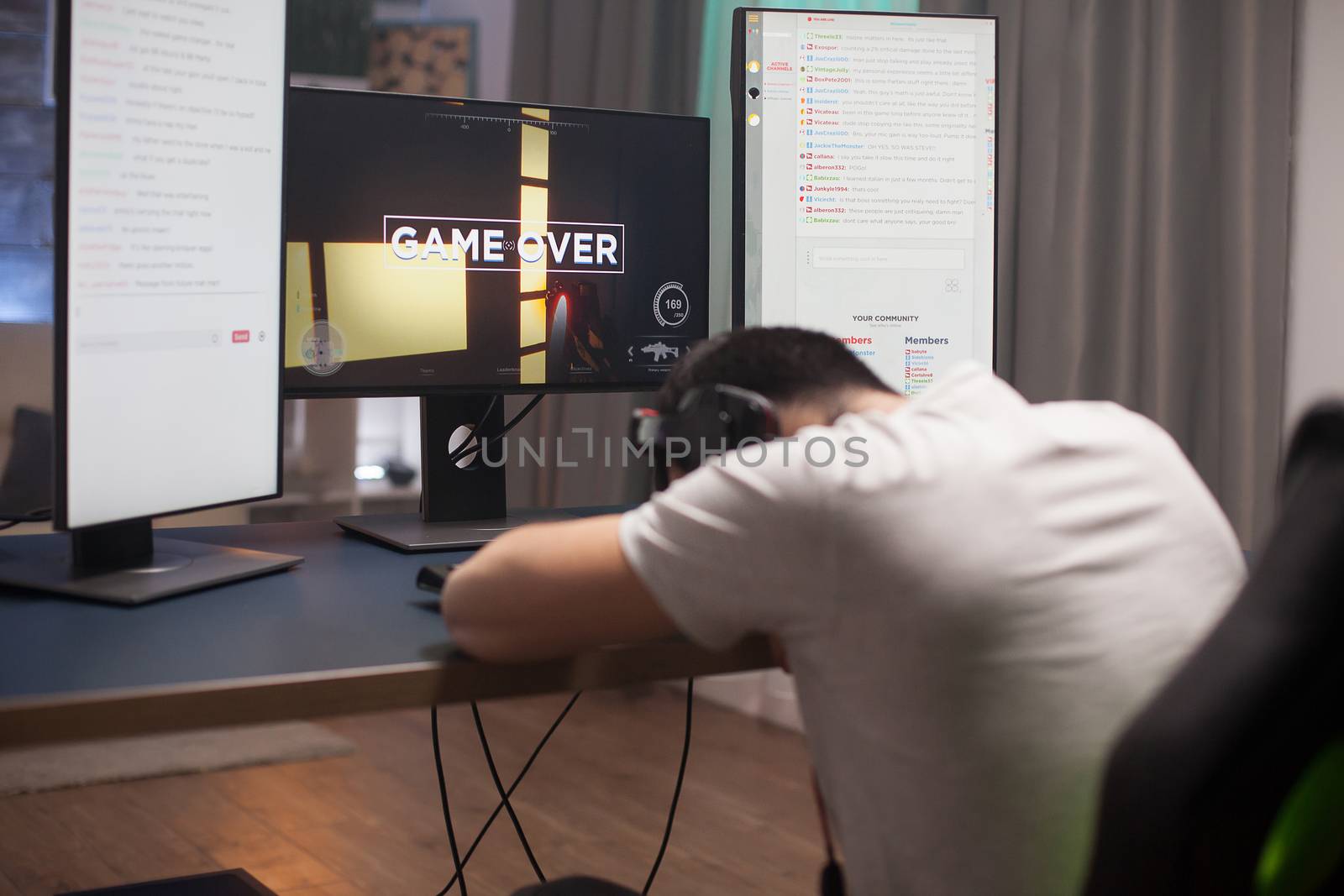 Disappointed young man keeping his head on the office because it's game over for him at online shooter games.