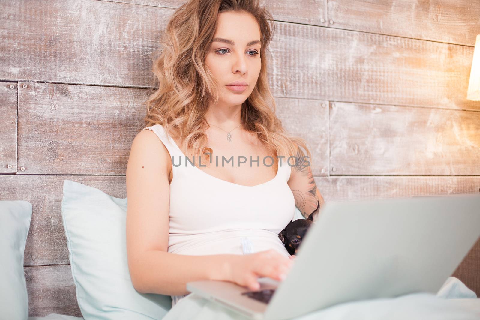 Young woman in pajamas at night in her bed by DCStudio