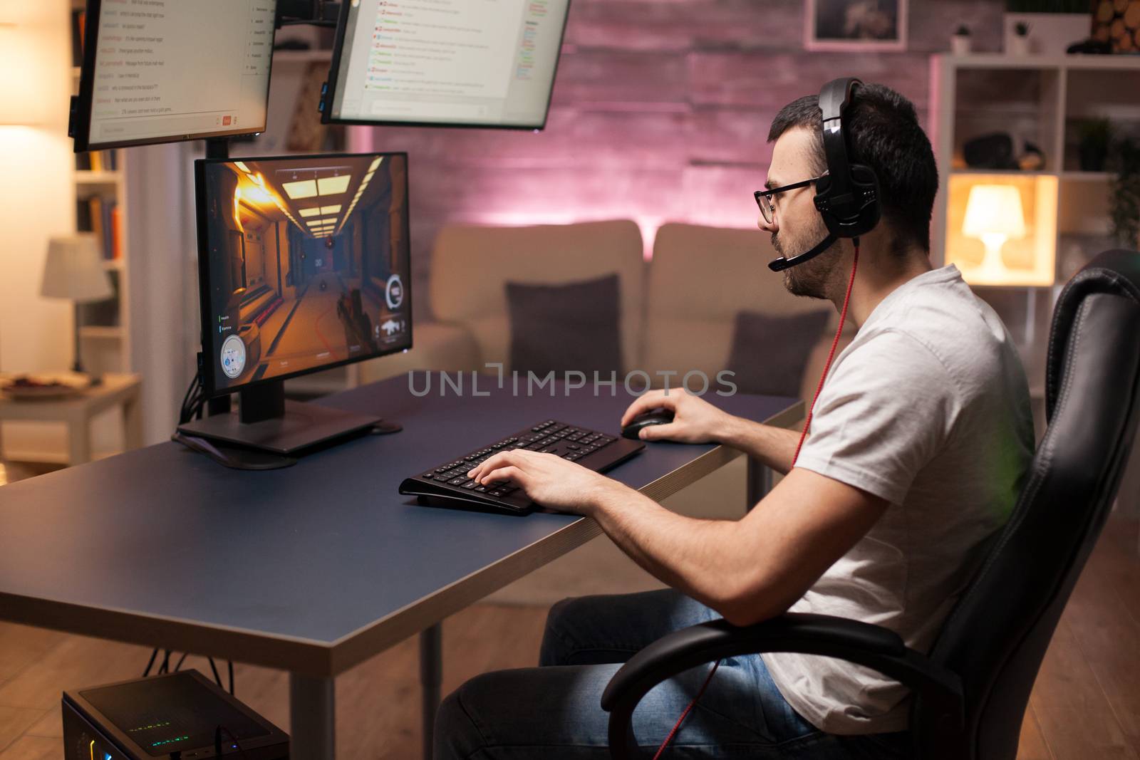 Man wearing headphones talking with his team while playing online shooter games.