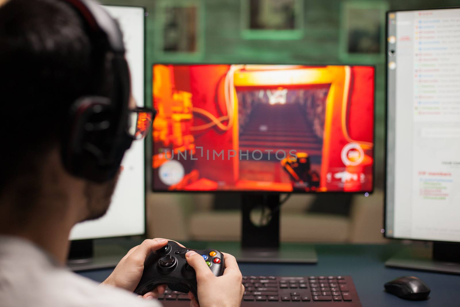 Close up of man using joystick while playing shooter games on powerful computer.